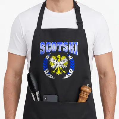 Scottish polish aprons - SCOTSKI text arching over a yellow and white eagle inside a blue and white wreath — shown on a black cotton canvas apron against a white background