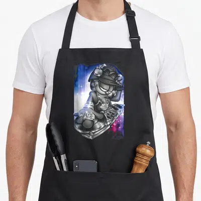Lazy dj life apron - Silver metallic cat DJ wearing diamond jewelry and headphones at a turntable against blue — shown on a black cotton canvas apron against a white background
