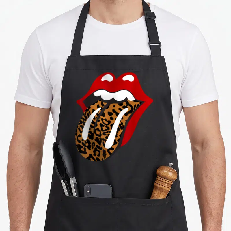 Rolling leopard apron - Cartoon mouth with red lips and leopard print tongue sticking out — shown on a black cotton canvas apron against a white background