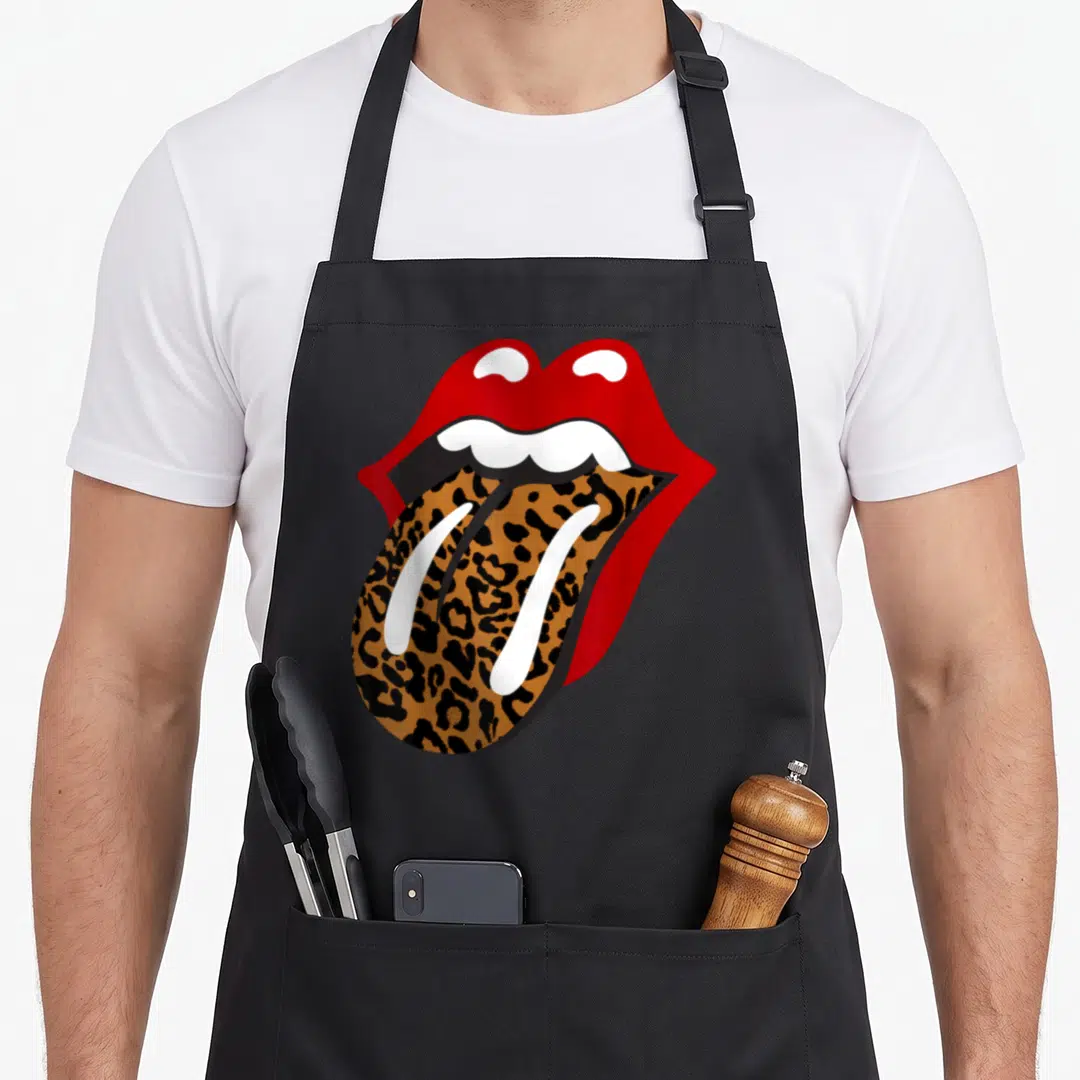 Rolling leopard apron - Cartoon mouth with red lips and leopard print tongue sticking out — shown on a black cotton canvas apron against a white background