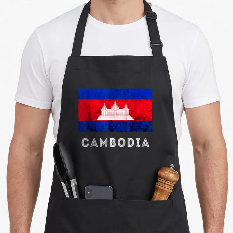 Cambodia cambodian apron - Distressed Cambodia flag graphic above white CAMBODIA text on black fabric — shown on a black cotton canvas apron against a white background