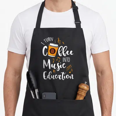 Turn personalized teacher aprons - Cartoon orange coffee cup surrounded by white text and orange musical notes — shown on a black cotton canvas apron against a white background