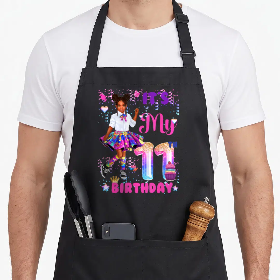 11th african american aprons - Cartoon girl with IT'S My 11TH BIRTHDAY text, confetti, hearts, and cupcake in pink — shown on a black cotton canvas apron against a white background