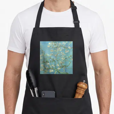 Almond van gogh apron - Blossoming tree branch with white flowers on a solid blue background — shown on a black cotton canvas apron against a white background