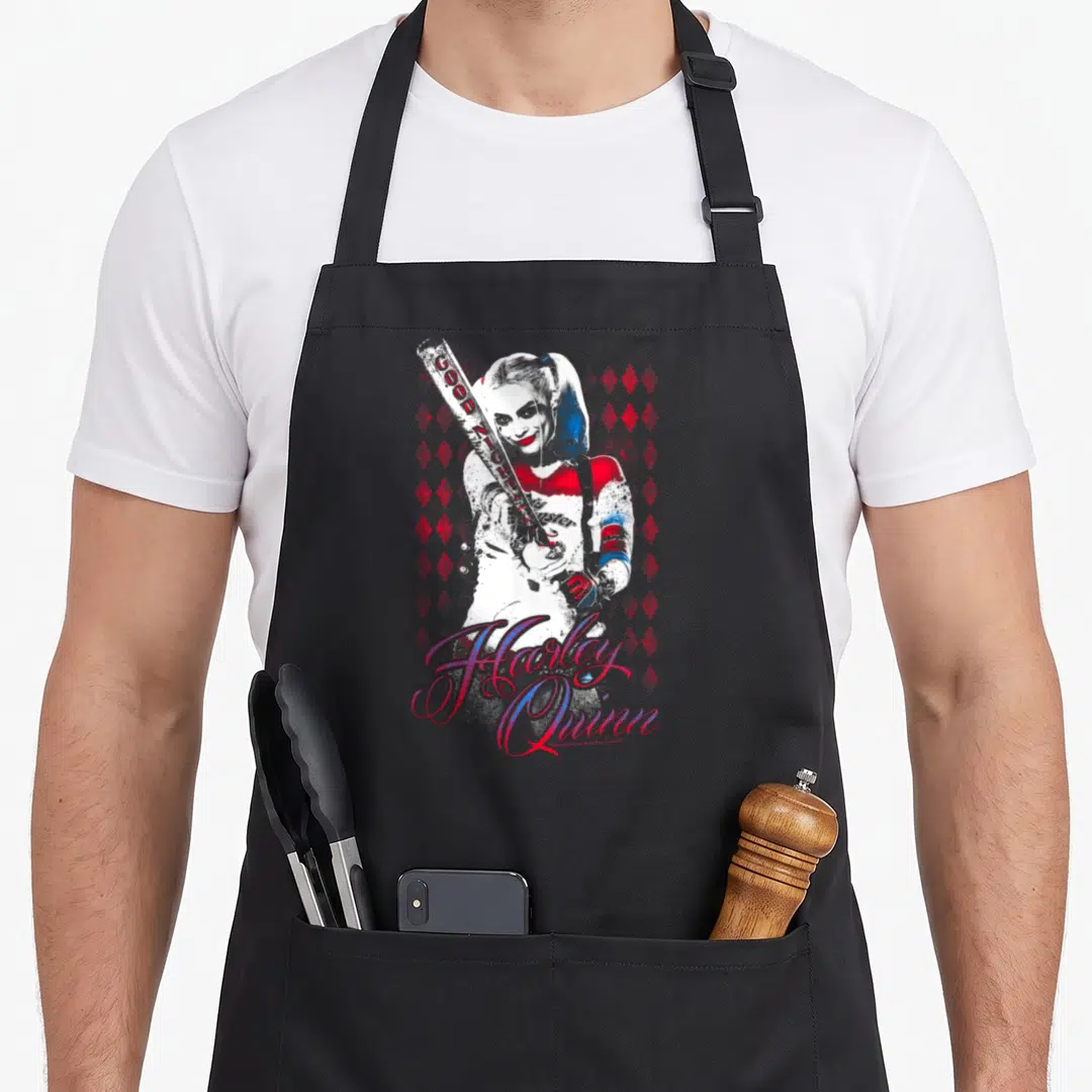 Suicide vehicle apron - Harley Quinn holding a bat with red diamonds and script text in white red blue distressed style — shown on a black cotton canvas apron against a white background
