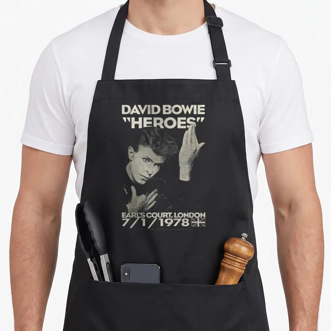 Earl david aprons - Halftone David Bowie portrait with Heroes text and Earl's Court 1978 date — shown on a black cotton canvas apron against a white background