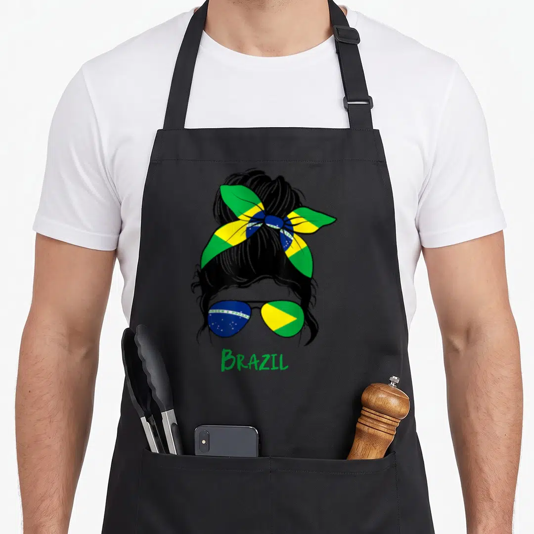 Brazil pride apron - Woman silhouette with flag headband, sunglasses, and green BRAZIL text — shown on a black cotton canvas apron against a white background