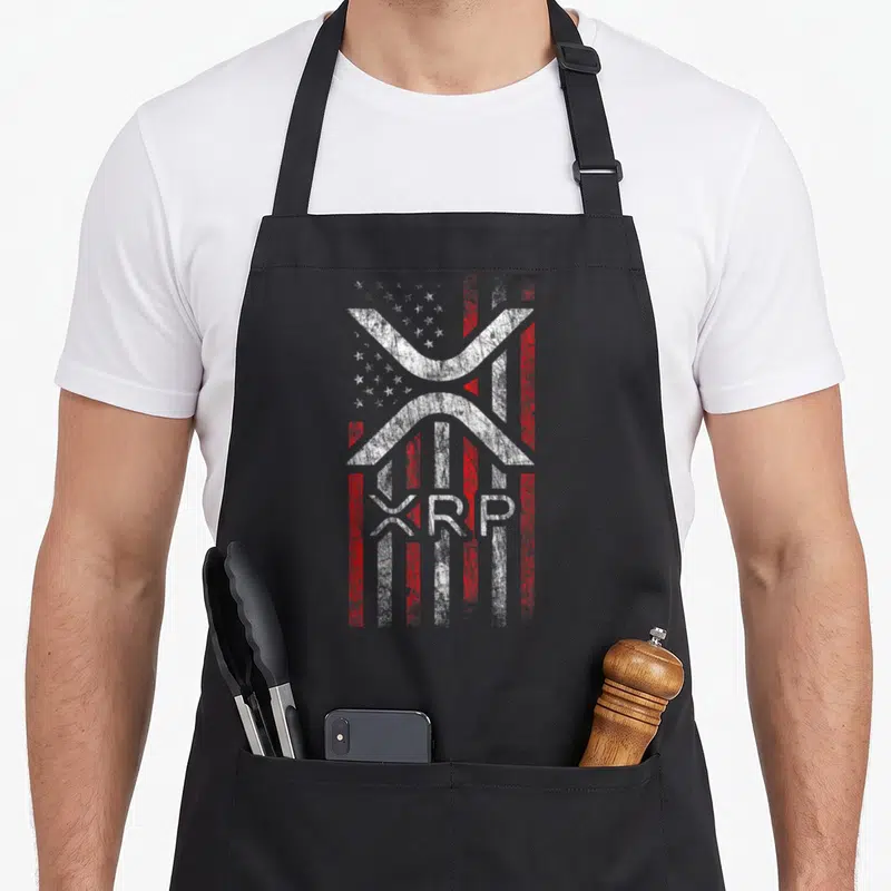 Crypto american flag apron - XRP logo over distressed US flag with text below in white and red — shown on a black cotton canvas apron against a white background