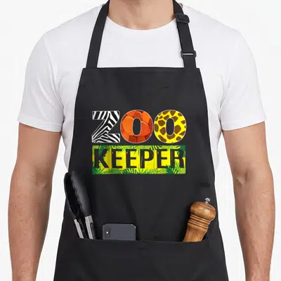 Safari halloween apron - ZOO KEEPER text with zebra stripe, orange swirl, giraffe spot, and jungle leaf patterns — shown on a black cotton canvas apron against a white background
