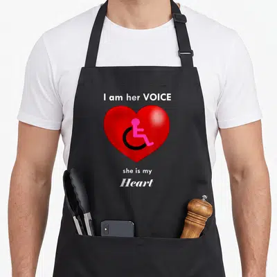 Wheelchair special aprons - Red heart with pink and black wheelchair symbol and advocacy text — shown on a black cotton canvas apron against a white background
