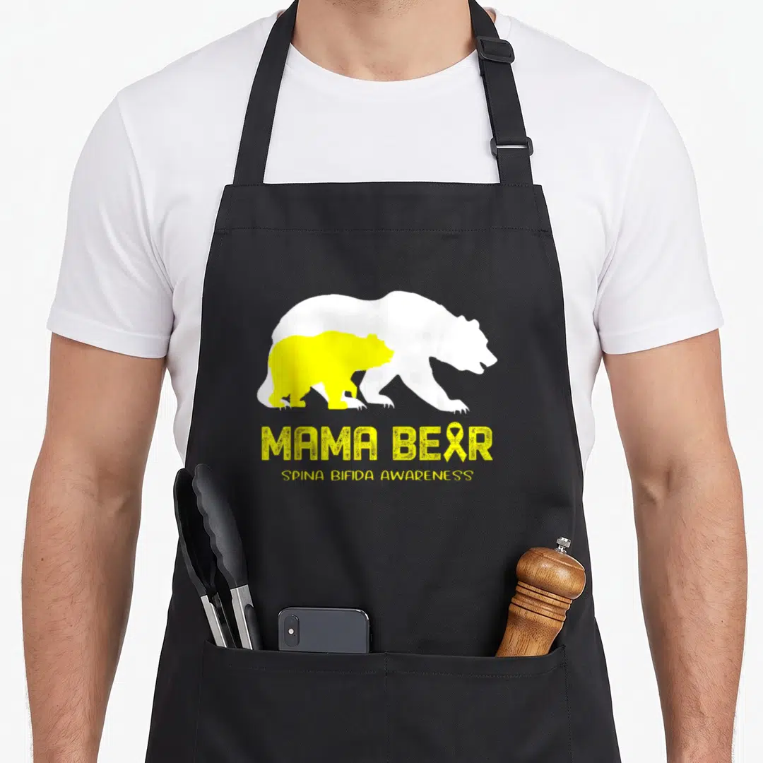 Spina mama bear apron - White and yellow bear silhouettes with MAMA BEAR text and spina bifida awareness ribbon — shown on a black cotton canvas apron against a white background