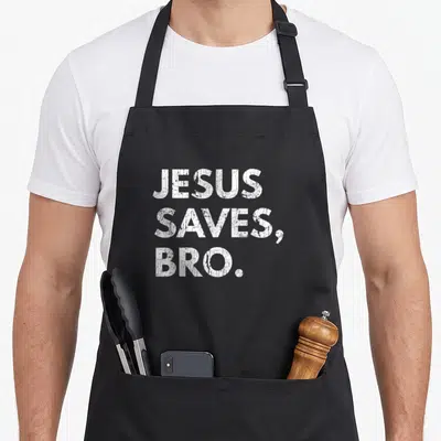Jesus pro apron - White distressed text reading JESUS SAVES, BRO. stacked in three lines — shown on a black cotton canvas apron against a white background