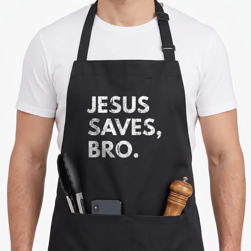 Jesus pro apron - White distressed text reading JESUS SAVES, BRO. stacked in three lines — shown on a black cotton canvas apron against a white background