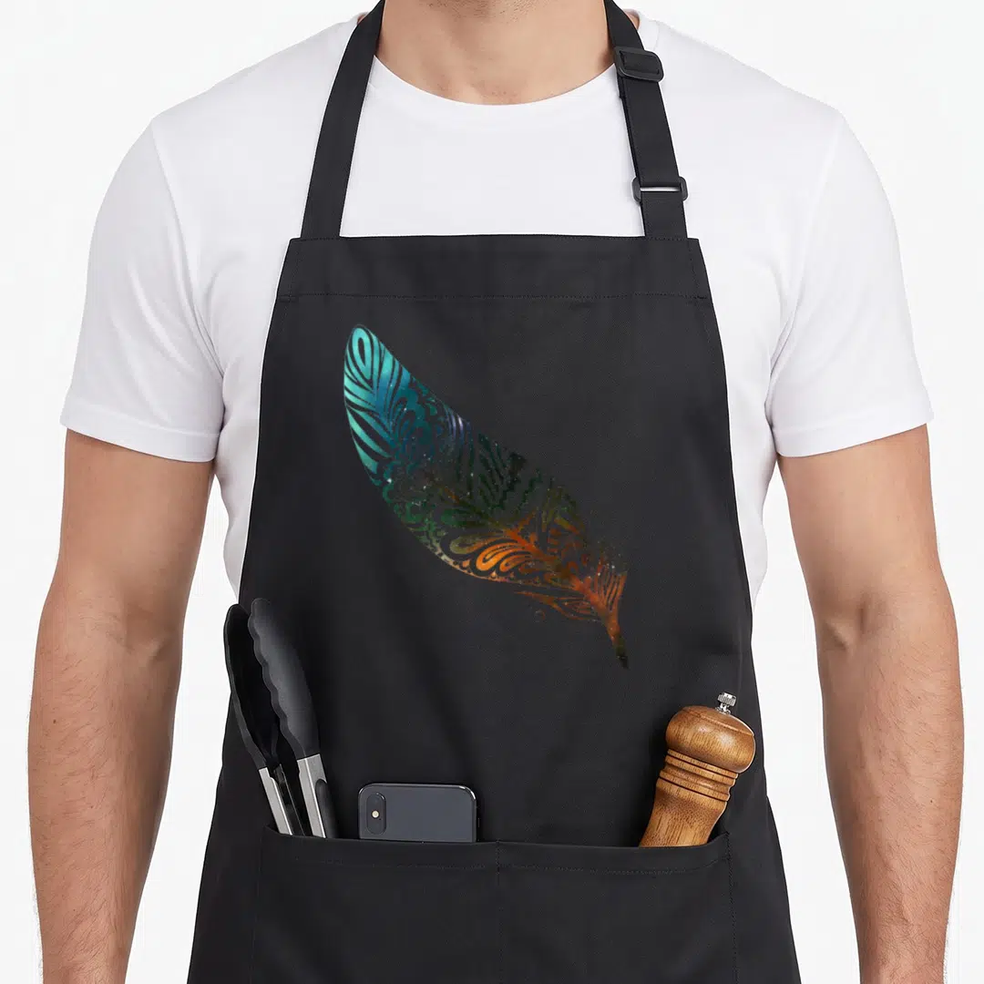Feather native american apron - Realistic feather print with blue, green, orange, and purple swirl patterns arranged — shown on a black cotton canvas apron against a white background