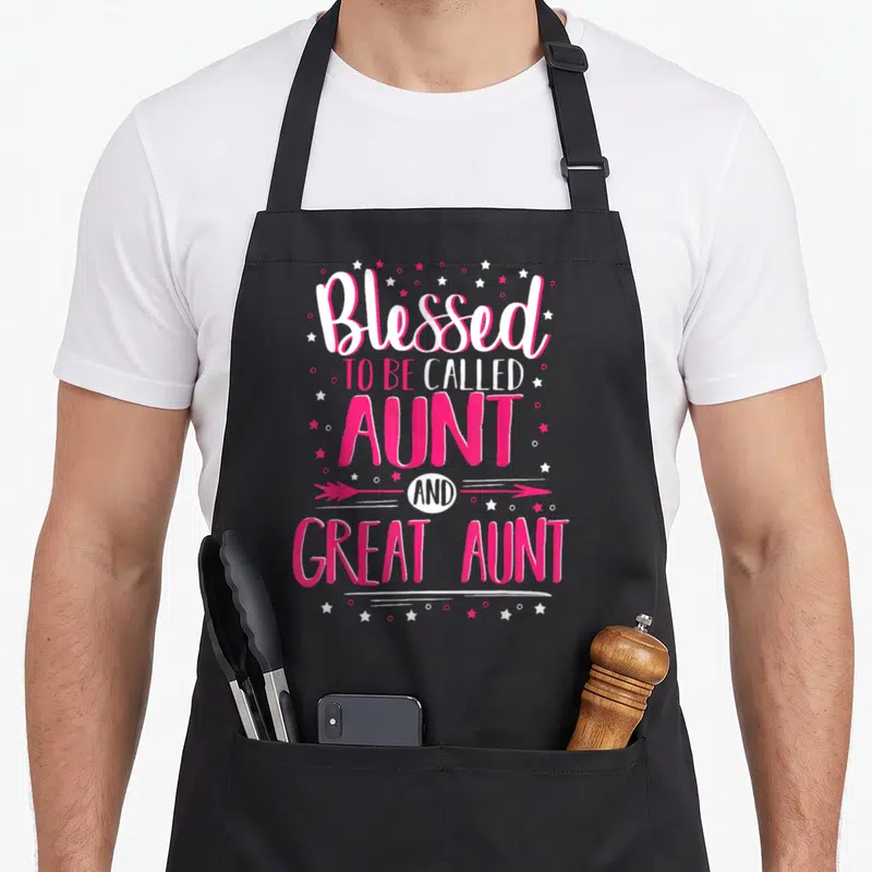 Aunt big sister apron - Pink and white vertical text Blessed to be called AUNT AND GREAT AUNT with stars and arrow — shown on a black cotton canvas apron against a white background