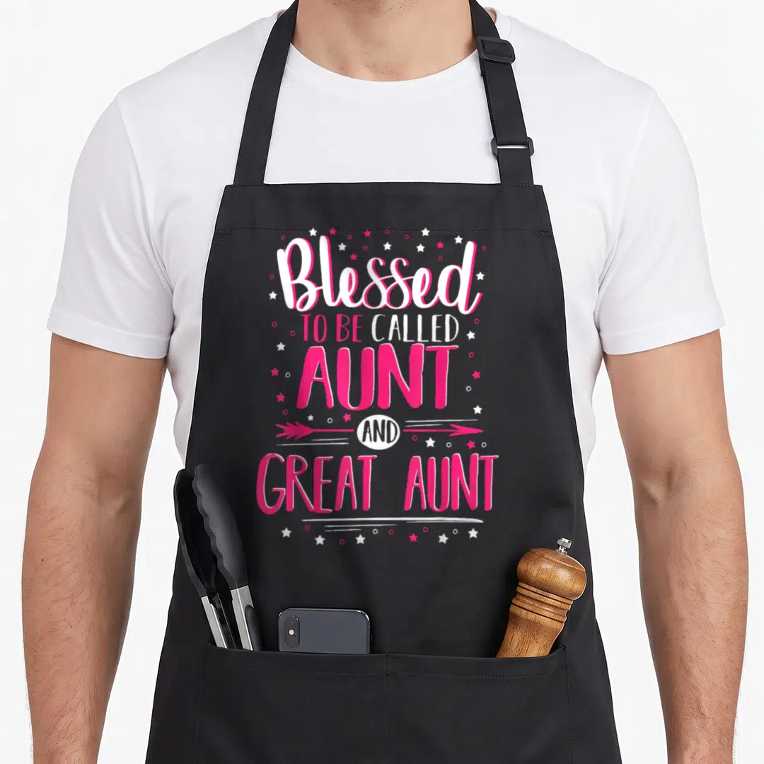 Aunt big sister apron - Pink and white vertical text Blessed to be called AUNT AND GREAT AUNT with stars and arrow — shown on a black cotton canvas apron against a white background