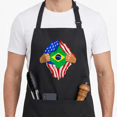 Brazilian blood apron - Two hands tearing USA flag revealing Brazilian flag with green yellow blue red white colors — shown on a black cotton canvas apron against a white background