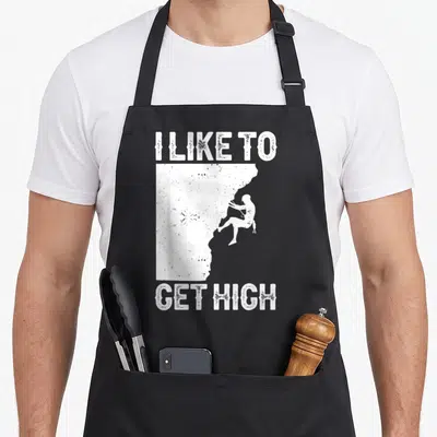 Rock bouldering apron - White distressed I LIKE TO GET HIGH text framing a rock climber silhouette on a cliff edge — shown on a black cotton canvas apron against a white background