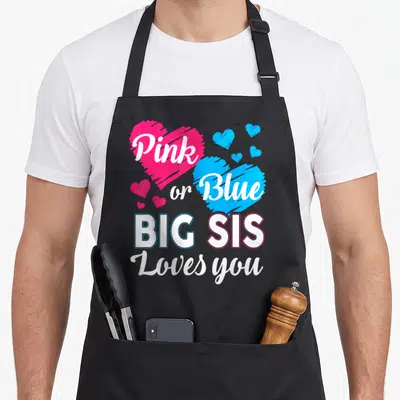 Sister gender reveal apron - Pink and blue hearts with Pink or Blue Big Sis Loves you text — shown on a black cotton canvas apron against a white background