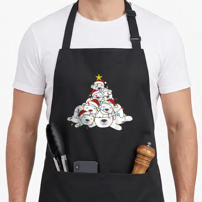 Polar christmas tree apron - Stacked white polar bears in a pyramid shape wearing red hats and wrapped in multi-colored — shown on a black cotton canvas apron against a white background