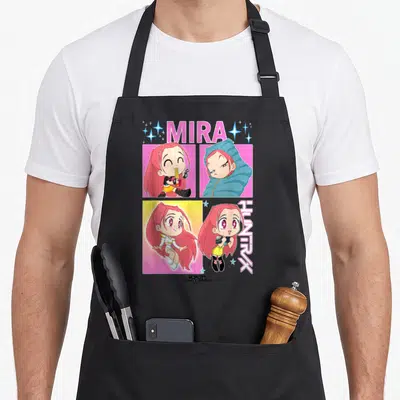 Mira trend apron - Cartoon girl portraits in pink blue and yellow with MIRA HUNTRX text — shown on a black cotton canvas apron against a white background