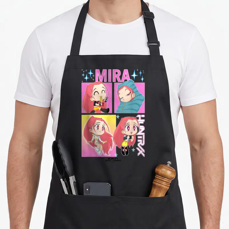 Mira trend apron - Cartoon girl portraits in pink blue and yellow with MIRA HUNTRX text — shown on a black cotton canvas apron against a white background