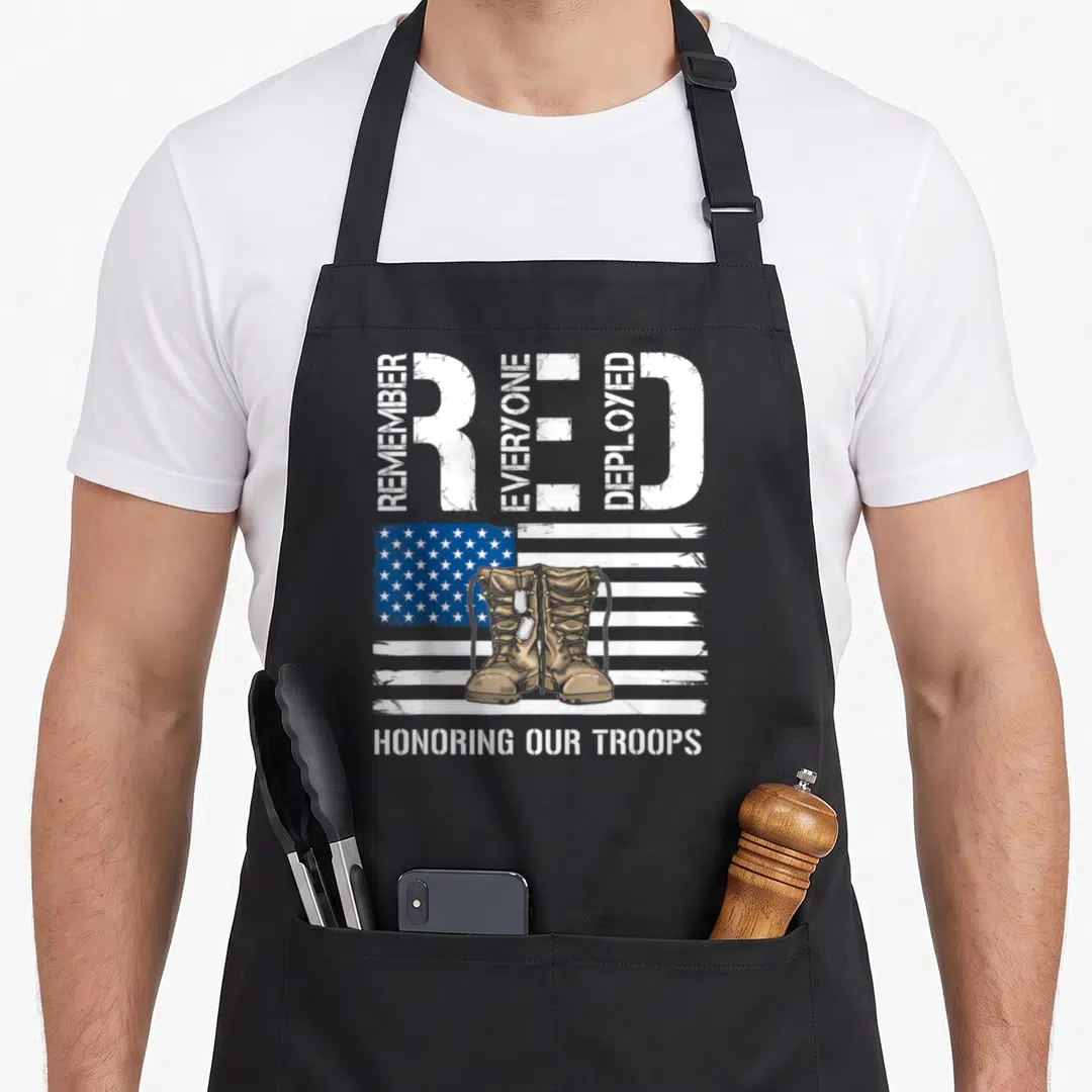 Remember veteran military apron - Tan combat boots with dog tags over distressed USA flag and vertical RED text — shown on a black cotton canvas apron against a white background