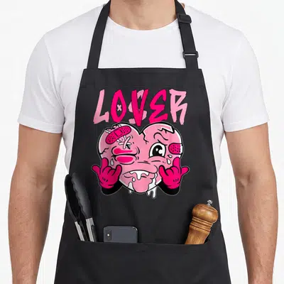 Loser drip apron - Pink LOVER text above a bandaged cartoon heart with two gesturing hands — shown on a black cotton canvas apron against a white background