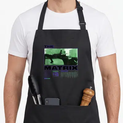 Smith matrix apron - Retro THE MATRIX NEO graphic with two men in green tint and purple text accents — shown on a black cotton canvas apron against a white background