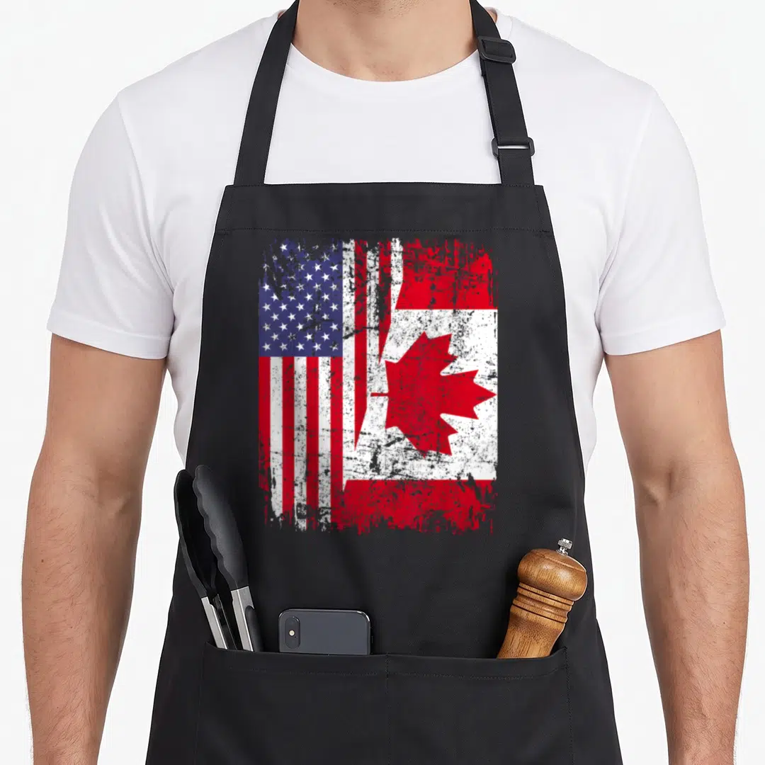 Root american flag apron - Merged distressed USA and Canada flags in red white blue on black fabric — shown on a black cotton canvas apron against a white background