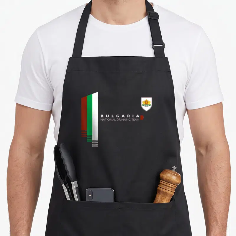 Bulgaria pride apron - Stylized flag and coat of arms with BULGARIA NATIONAL DRINKING TEAM text and red mug — shown on a black cotton canvas apron against a white background