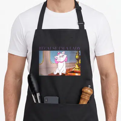 Marie marietta apron - Purple Because I'm A Lady text above a white cat with a pink bow on a brown table — shown on a black cotton canvas apron against a white background