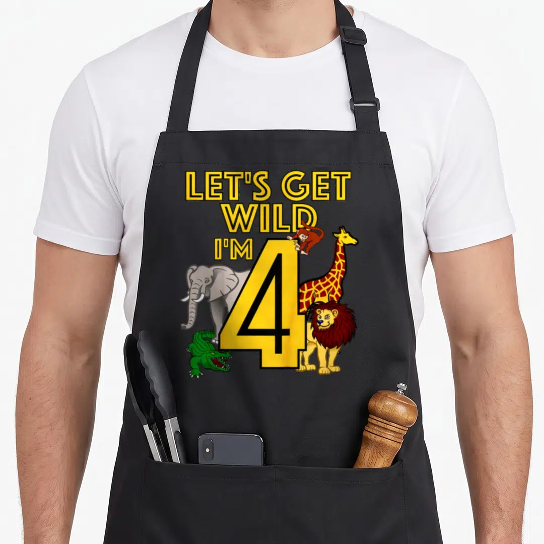 Jungle animal birthday apron - Yellow number 4 with elephant, giraffe, lion, crocodile, and monkey surrounding stacked — shown on a black cotton canvas apron against a white background