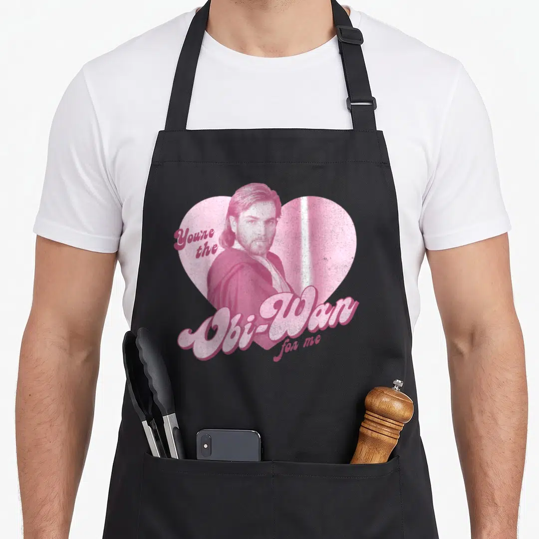 Portrait star apron - Pink heart portrait of Obi-Wan Kenobi with retro Youre the Obi-Wan for me text — shown on a black cotton canvas apron against a white background