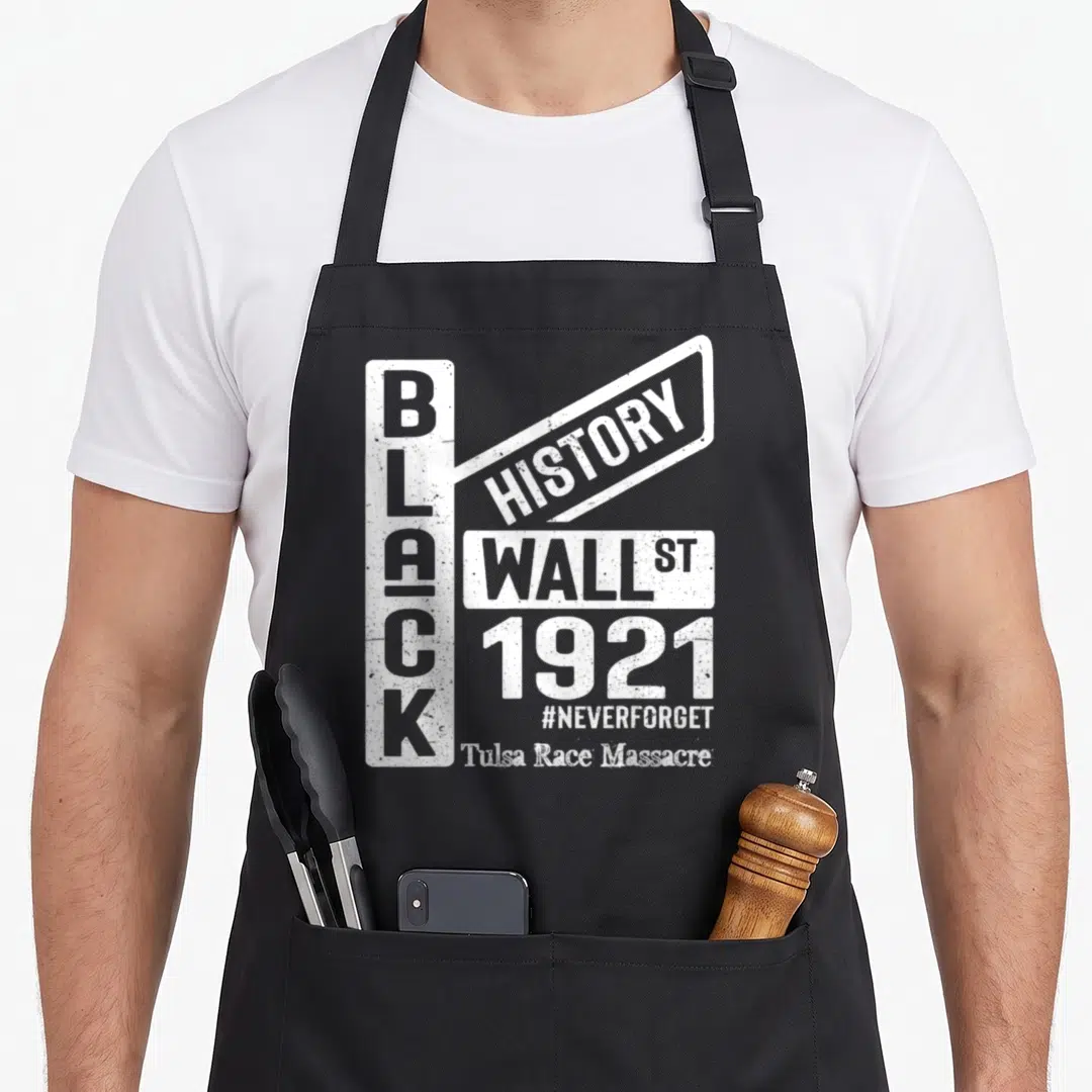 Wealth tulsa apron - White text reading Black History Wall St 1921 Tulsa Race Massacre on black apron — shown on a black cotton canvas apron against a white background
