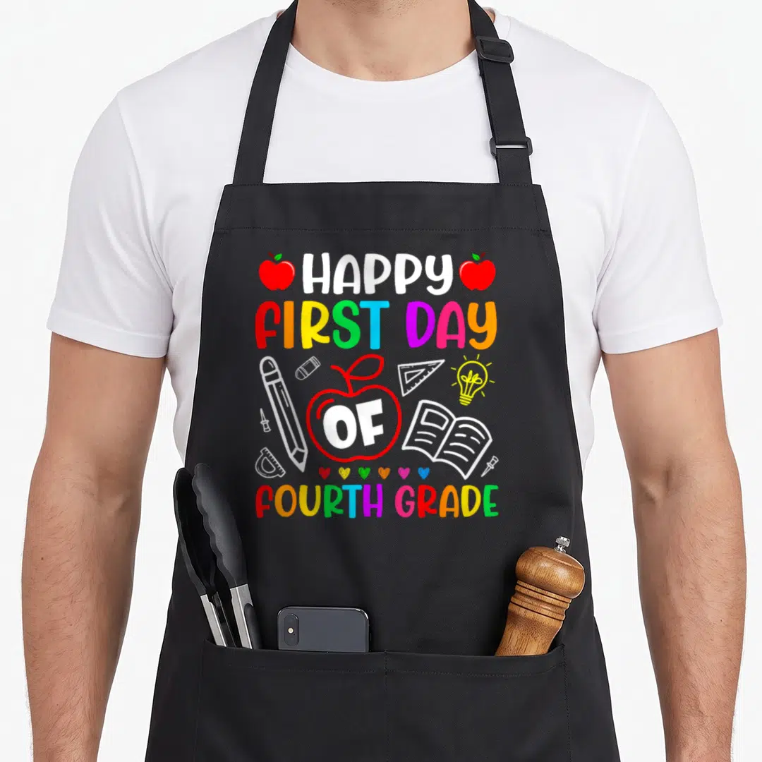 Fourth day grade apron - Cartoon school supplies surround stacked text HAPPY FIRST DAY OF FOURTH GRADE with OF inside — shown on a black cotton canvas apron against a white background