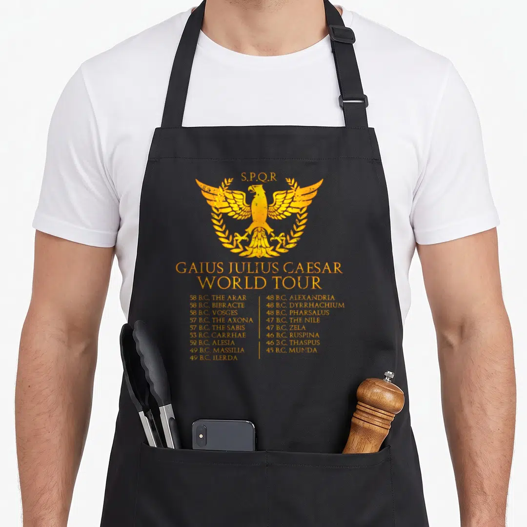 Gaius bloody caesar apron - Yellow eagle laurel wreath SPQR Gaius Julius Caesar World Tour battle list — shown on a black cotton canvas apron against a white background