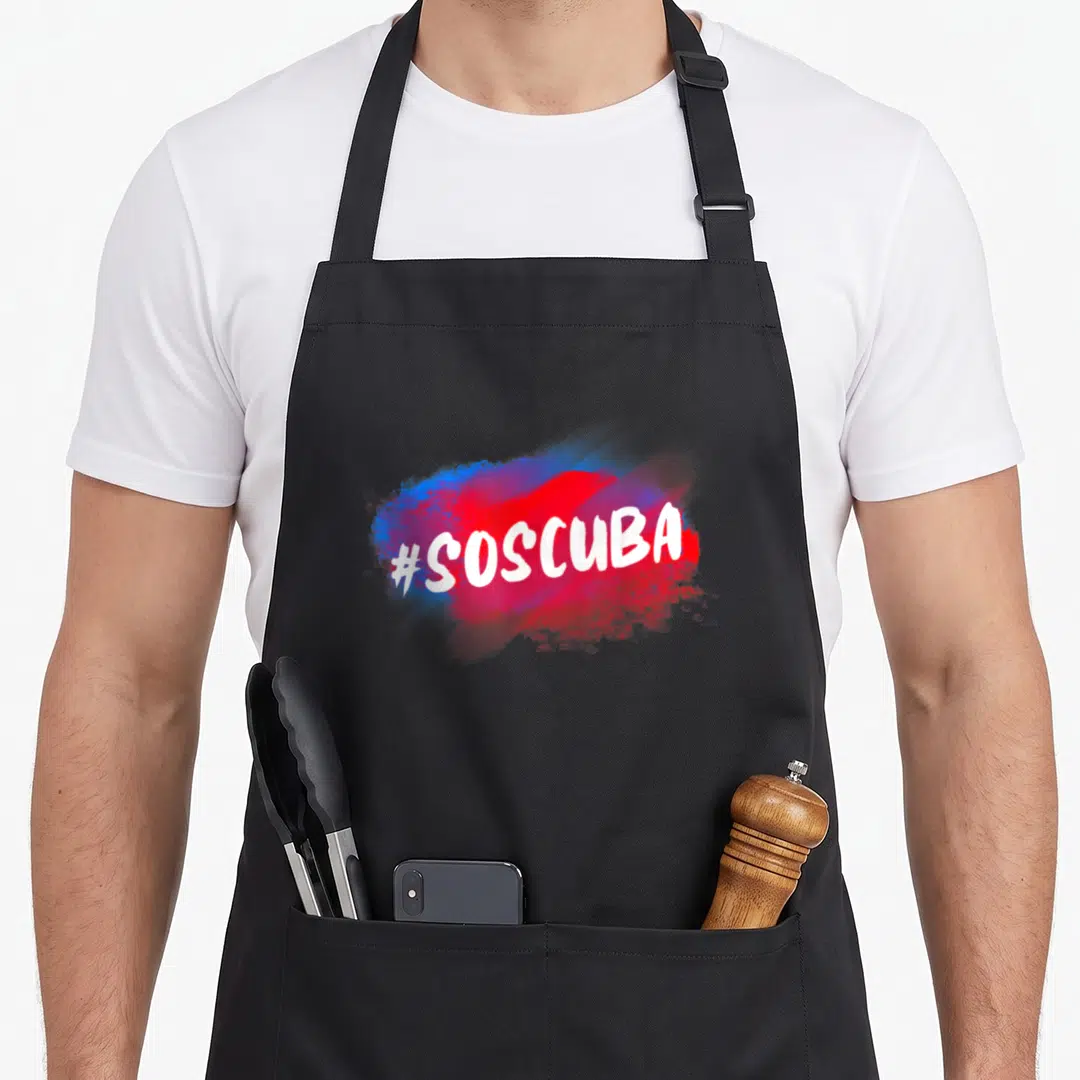 Abajo cuba libre apron - #SOSCUBA white text on red and blue paint splash graphic — shown on a black cotton canvas apron against a white background