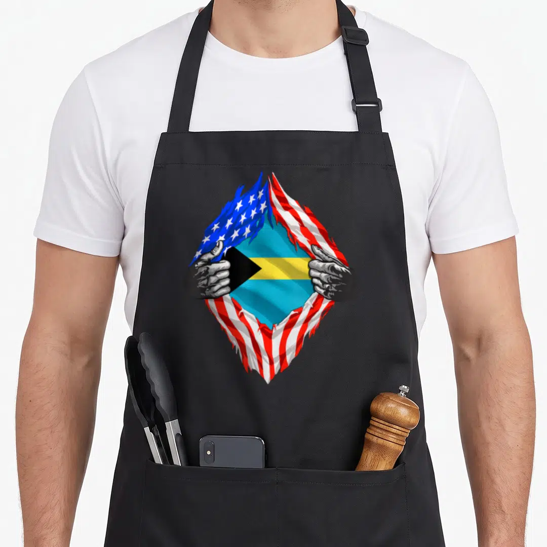 Bahamas bahamian american flag apron - Two hands tear USA flag to reveal Bahamian flag in blue red white yellow — shown on a black cotton canvas apron against a white background