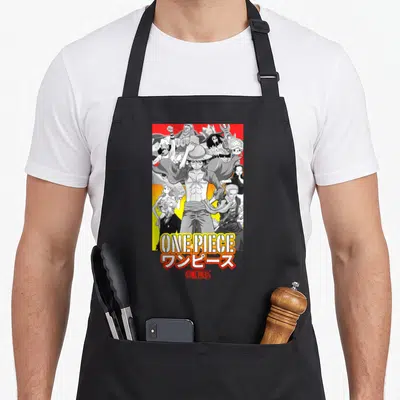 Collage anime character apron - Luffy surrounded by crew with ONE PIECE text and Japanese characters in grey yellow red — shown on a black cotton canvas apron against a white background
