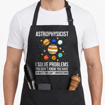Astronomy astrophysicist apron - Cartoon planets and stars surround white text reading I solve problems you don't know — shown on a black cotton canvas apron against a white background