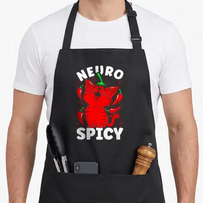 Neurodivergent cat apron - Red cartoon cat centered between NEURO and SPICY text surrounded by chili peppers — shown on a black cotton canvas apron against a white background