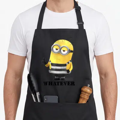 Despicable whatever apron - Yellow minion giving thumbs up with WHATEVER text below in black — shown on a black cotton canvas apron against a white background