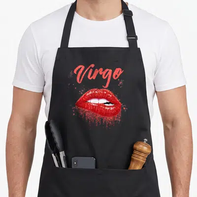Virgo zodiac lip birthday apron - Red script Virgo text above glittery red lips showing white teeth — shown on a black cotton canvas apron against a white background