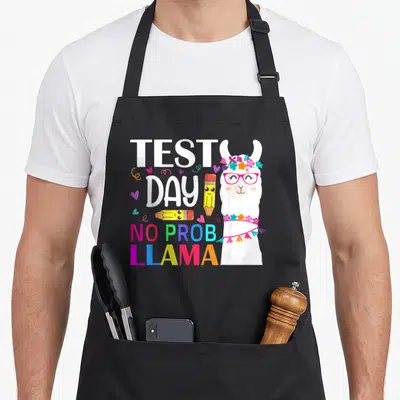 Prob test kitchen apron - Cartoon llama with glasses and pencils next to text TEST DAY NO PROB LLAMA — shown on a black cotton canvas apron against a white background