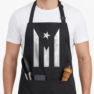 Rico flag puerto apron - Three vertical white bars with pointed tops and a centered white star in distressed style — shown on a black cotton canvas apron against a white background