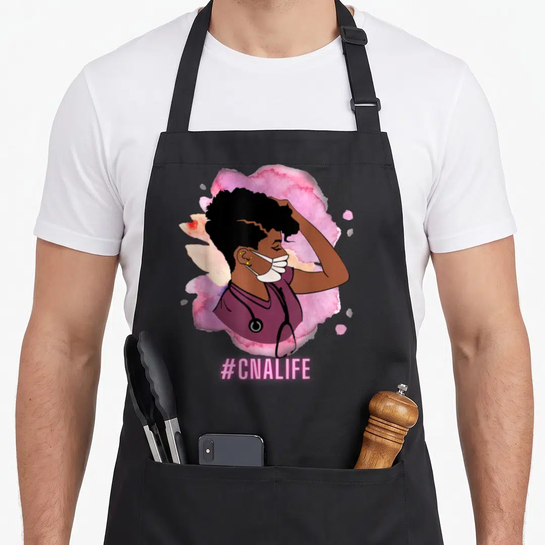 Certified nursing aprons - Cartoon nurse in purple scrubs and mask over pink splash with #CNALIFE text below — shown on a black cotton canvas apron against a white background