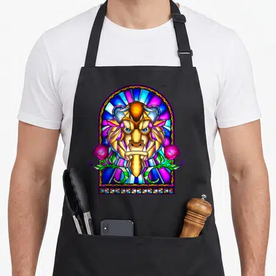 Window stained apron - Cartoon lion head in arched stained glass window with two pink roses and green leaves — shown on a black cotton canvas apron against a white background