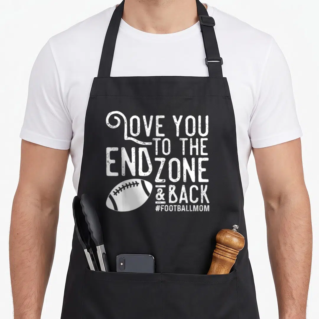 End football apron - White distressed text reading LOVE YOU TO THE END ZONE & BACK above a white football graphic — shown on a black cotton canvas apron against a white background