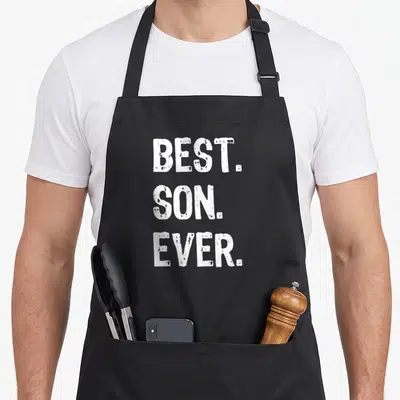 Funny dad and son aprons - White stacked text reading BEST. SON. EVER. in distressed block letters on grey background — shown on a black cotton canvas apron against a white background